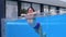 Happy caucasian woman swims in an outdoor pool with a transparent wall in a hotel