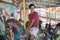 Happy Caucasian young handsome man on merry go round at the amusement park