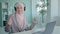 Happy celebrating female Muslim worker in hijab Islamic businesswoman gunny listening music with headphones and laptop