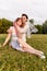 A happy charming bride in a white dress with a white veil and a bridesmaid in a blue dress with a pink veil are sitting