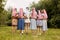 Happy charming bride in a white dress with a white veil and bridesmaids with pink veils hugging and standing with their