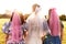 Happy charming bride in a white dress with a white veil and two bridesmaids with pink veils hugging and standing with