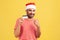 Happy cheerful bearded man in santa claus hat pointing finger at credit card in his hand, interest-free payment on holidays,