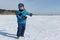 Happy cheerful boy with a snowball    to walk along the snowy track