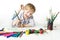 Happy cheerful child drawing with brush in album