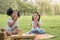 Happy cheerful ethnic girls eat apple together at outdoors park , Relationship little kids, Diverse ethnic concept