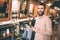 Happy and cheerful guy is standing in a barbershop and looking to the camera. He is smiling. Man is holding a cover