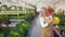 Happy, cheerful lady working in greenhouse, taking care of plants.