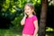 Happy cheerful little girl, child talking on phone laughing, young kid with a smartphone, phone call outdoors, portrait, copy