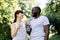 Happy cheerful multiethnic athletic couple, Caucasian woman and African man, with water bottles, communicating looking