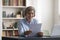 Happy cheerful retired mature business woman reading paper document