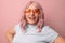 Happy cheerful young 30s woman blogger in bright orange stylish glasses shows his tongue and beautiful white teeth