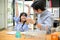 A happy and cheerful young Asian girl raises her hands after finishing a science class