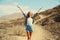 Happy cheerful young woman raising her hands up on hiking trail on top of the mountain, Tenerife, Canary Islands, Spain