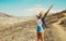 Happy cheerful young woman raising her hands up on hiking trail on top of the mountain, Tenerife, Canary Islands, Spain