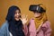 Happy cheerfull Asian muslim mother and daughter playing games on vr glasses