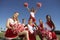 Happy Cheerleaders Holding Pompoms On Field