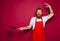 Happy chef with beard and red apron cooks with pan