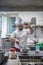 Happy chef cooking in his kitchen