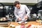 happy chef cutting fried meat with knife