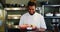 Happy chef holding tray of food in kitchen