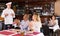 Happy chef of pizza restaurant listening to praises of guests