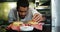 Happy chef placing skewers on burger in kitchen