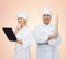 Happy chefs or cooks couple holding rolling pin