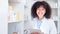 Happy chemist smiling and laughing, stocktaking in a drugstore and using a tablet for online customer orders. Young