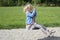 Happy Child blond girl (age 5) rids on Flying Fox play equipment in a children\'s playground.