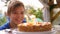 Happy child blows out candles on a birthday cake. Close up. slow motion.