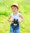 Happy child boy with binoculars outdoors in summer
