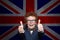 Happy child boy showing thumb up against the UK flag background. Learn English its cool