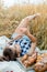 Happy child with bread in yellow autumn wheat field. A field with mature ears.girl sits on a bedspread, fresh fruits and berries,