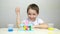 A happy child conducts experiments with chemicals by mixing them in a test tube. The boy laughs as he looks at the foam