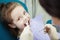 Happy child in dentist chair with napkin on chest