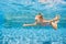 Happy child dive underwater with fun in swimming pool