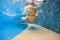 Happy child dive underwater with fun in swimming pool