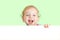 Happy child face behind blank advertising banner