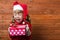 Happy child with a gift on a wooden background with copy space.