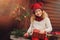 Happy child girl celebrating christmas outdoor at cozy wooden country house