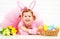 Happy child girl in costume Easter bunny rabbit with eggs and f