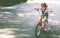 Happy child girl cyclist riding a bike