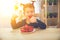 Happy child girl eats strawberries in summer home kitchen