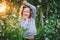 Happy child girl fooling on summer field with flowers