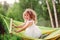 Happy child girl having fun and relaxing in hammock in summer