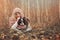 Happy child girl with her spaniel dog on cozy warm autumn walk