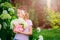 Happy child girl with hydrangea bouquet playing outdoor in cozy summer garden