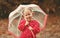 Happy child girl laughing with an umbrella in rain