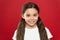 Happy child girl with long hair on red background. Happiness and joy. Positive emotions. Child care and upbringing. Kid